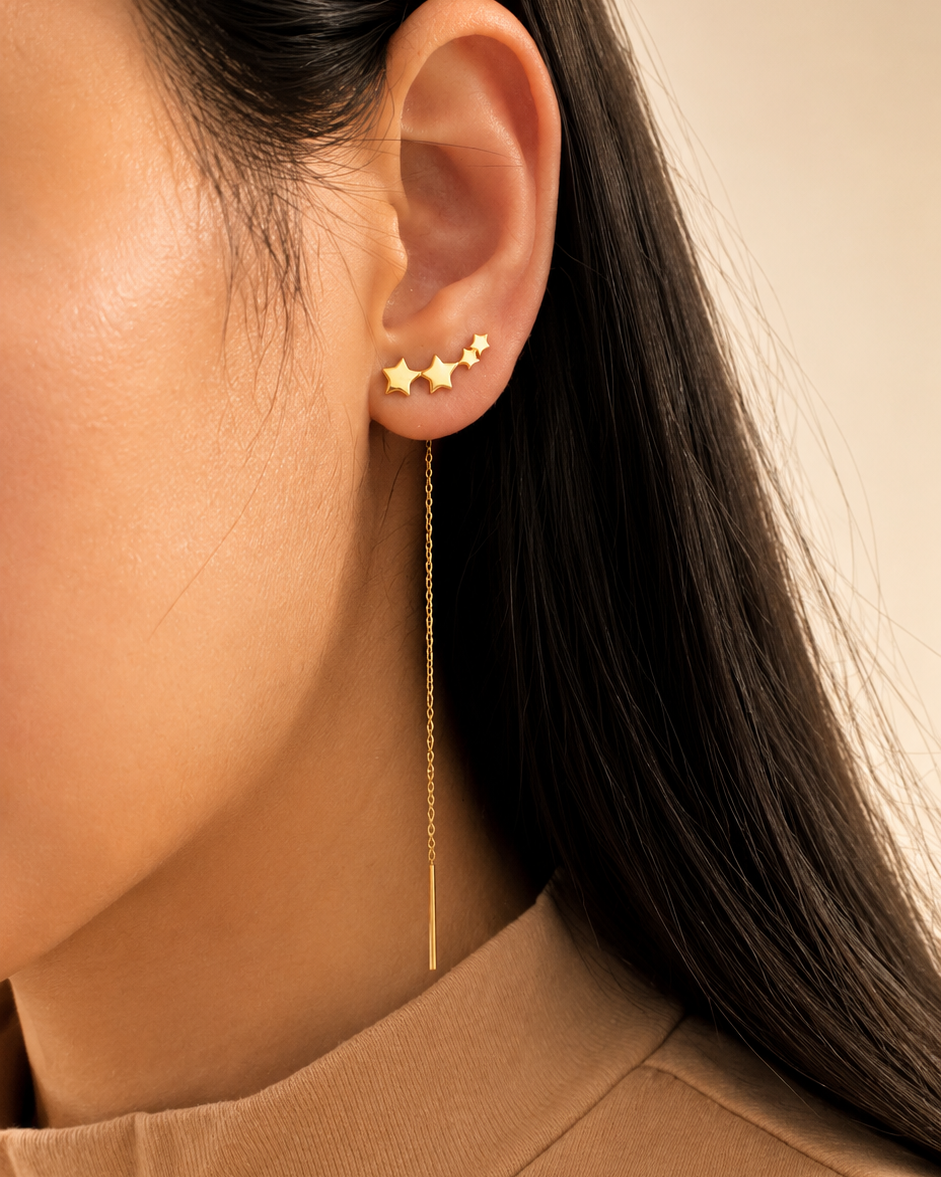 Close-up of a person wearing gold star-shaped earrings 